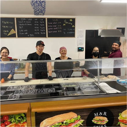 youth staff behind takeout counter at M&R store